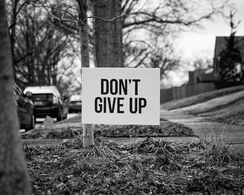 don't give up sign black white distorted